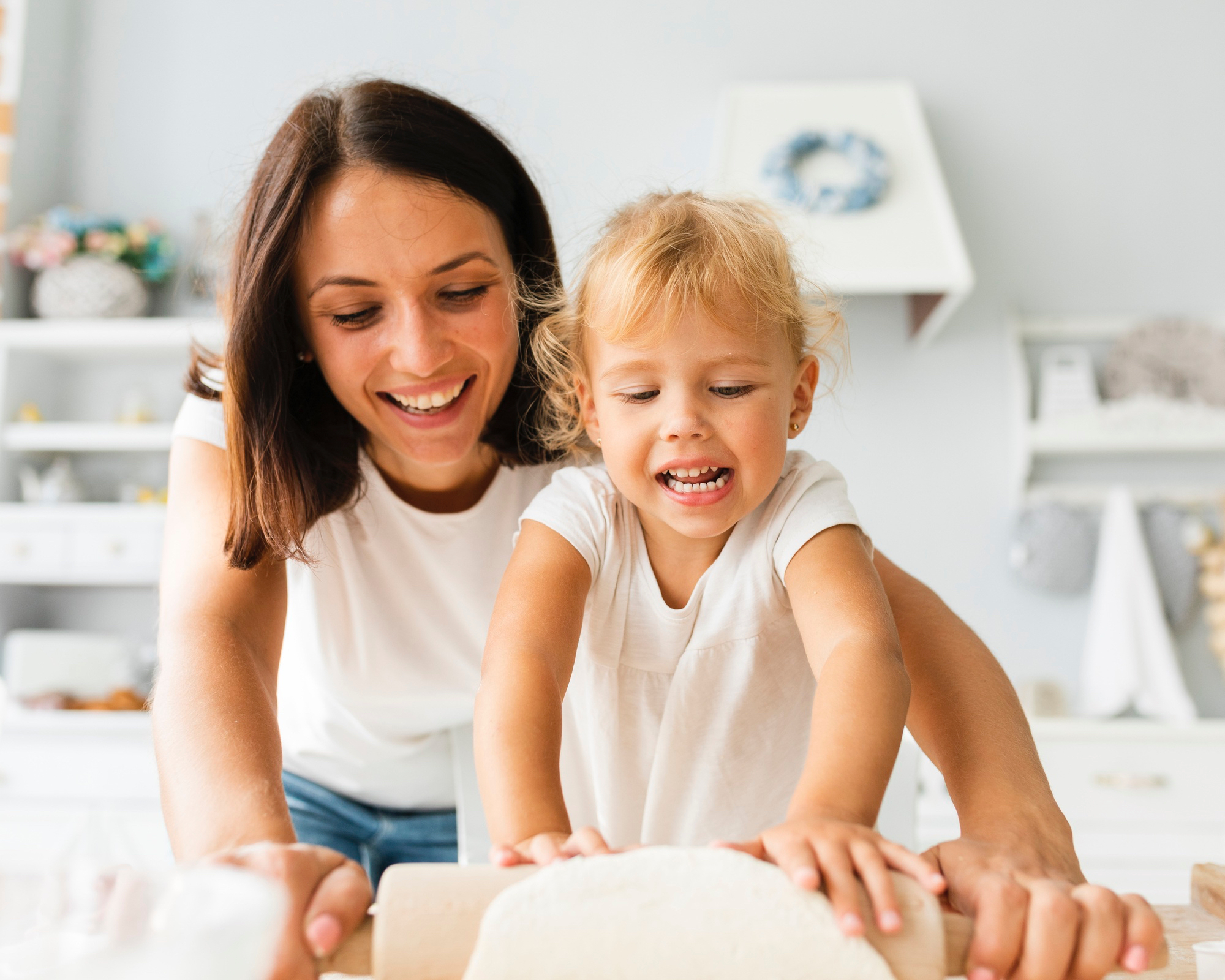 Una mujer adulta y un niño pequeño sonriendo en un entorno hogareño luminoso.