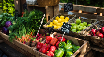 Frutas y verduras en un mercado de agricultores. Pimientos, zanahorias, limones y manzanas en pequeñas cestas.