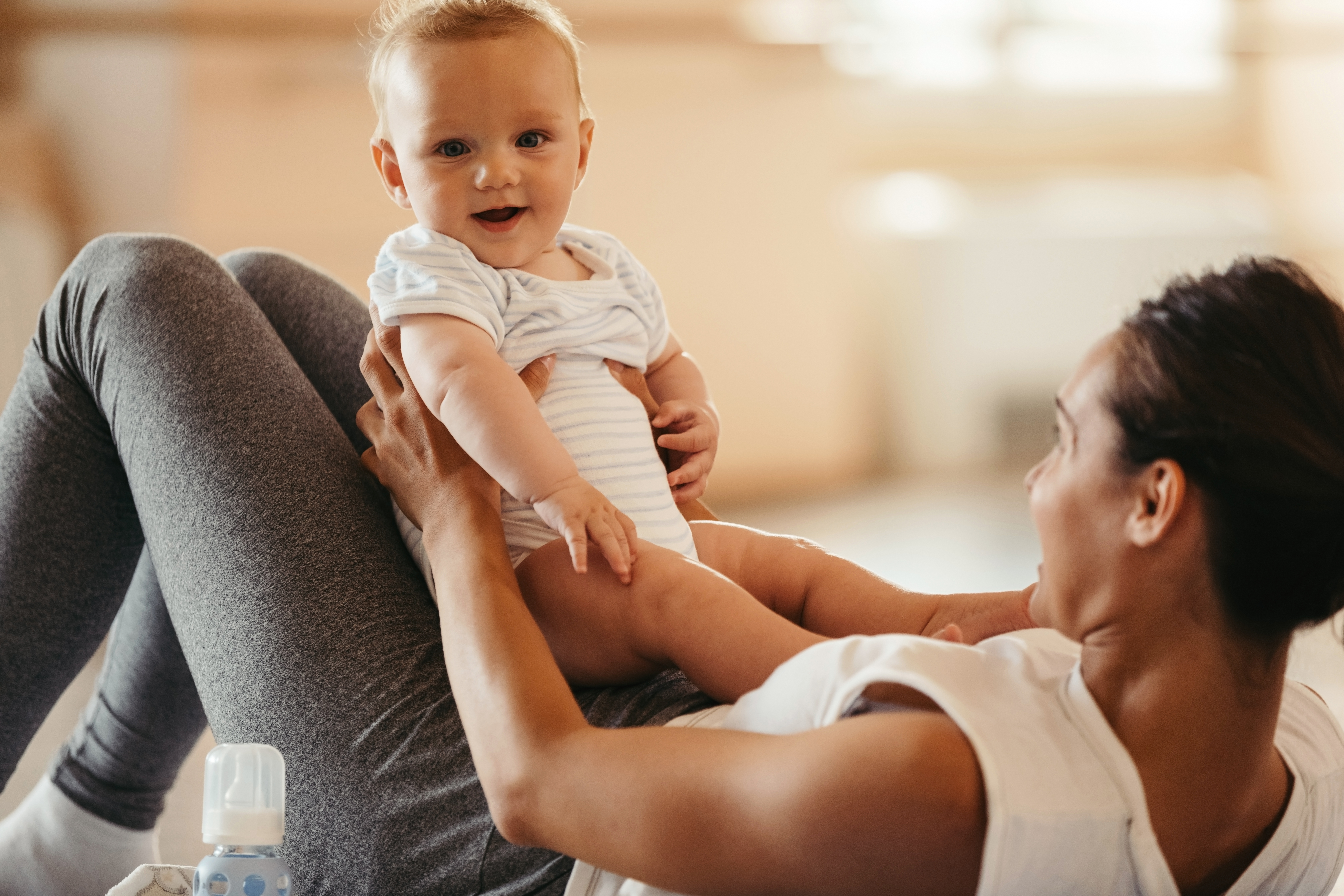 Bebé sonriente sostenido por mujeres