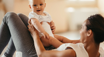 Bebé sonriente sostenido por mujeres