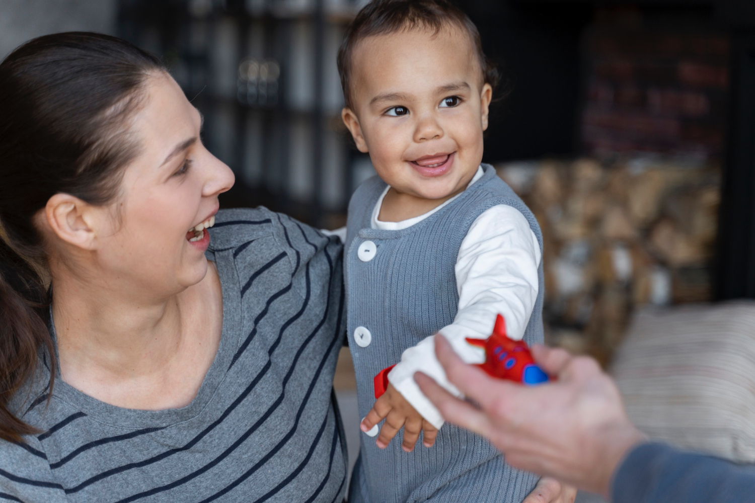 Mujer adulta sosteniendo a un niño pequeño sonriente.