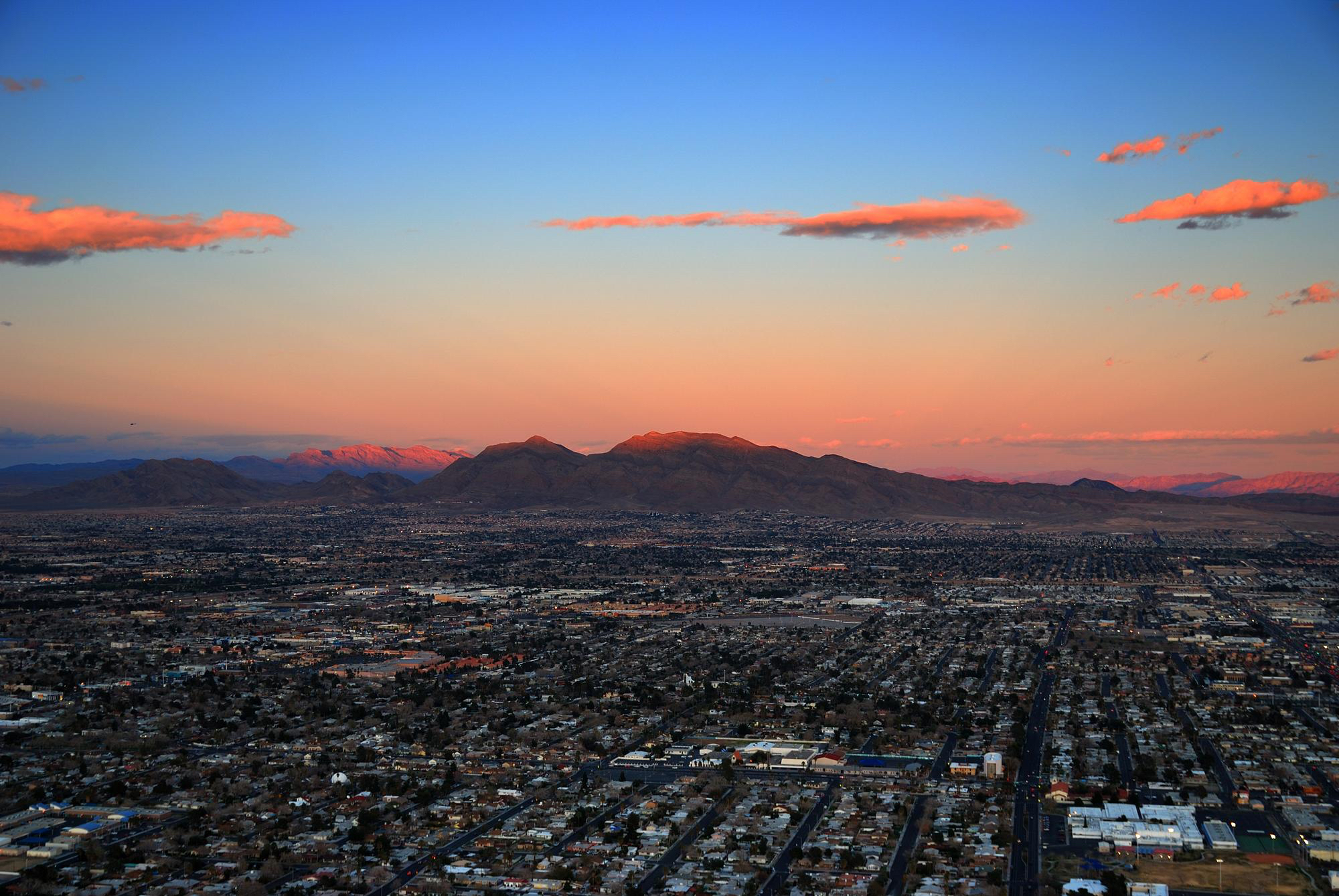 Toma aérea del horizonte de Nevada durante la puesta de sol, montañas al fondo y edificios de la ciudad al frente