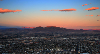 Toma aérea del horizonte de Nevada durante la puesta de sol, montañas al fondo y edificios de la ciudad al frente